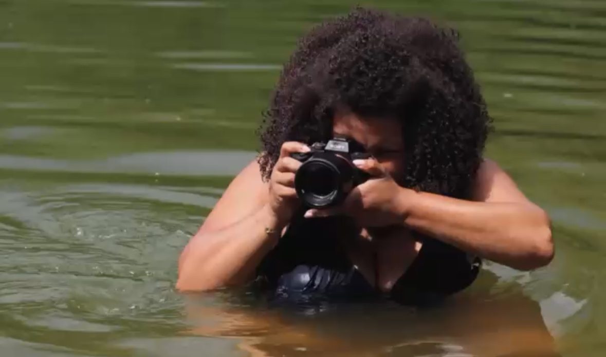 Fotografin Jessy Portrait von Jessy mit Kamera Achtsame Frauenfotografie – Woman of Color Fotografin