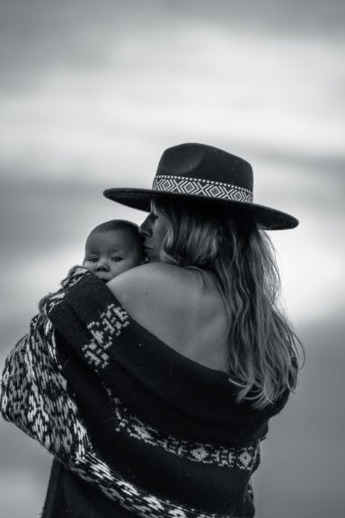 Mutter küsst ihr Kind auf den Kopf – inniger Moment der Mutterschaftsfotografie