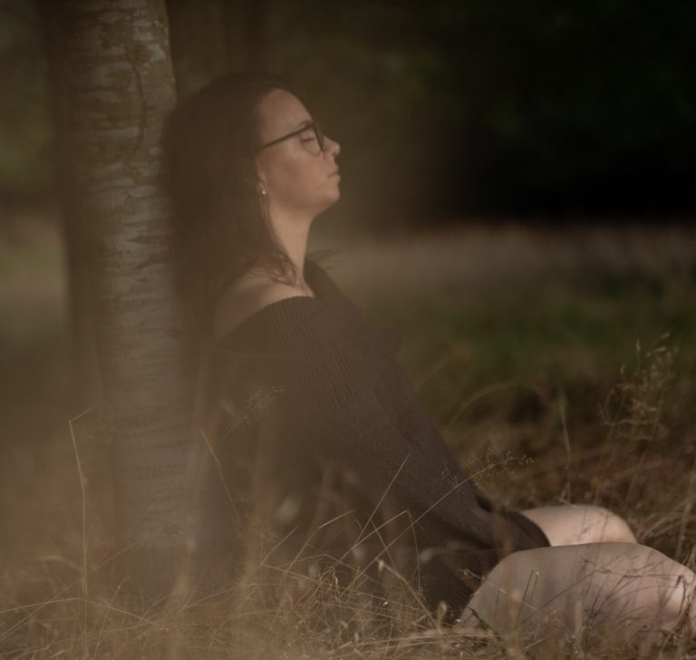 Frau sitzt im warmen Abendlicht an einer Birke, Seitenprofil, Empowerment Fotoshooting in der Natur
