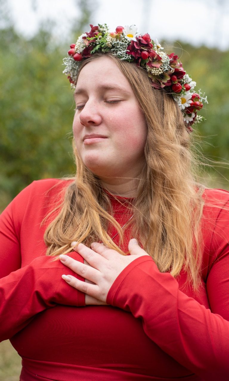 Achtsame Frauenfotografie – Body and Soul Stories Frau mit geschlossenen Augen und Blumenkranz legt die Hände auf ihr Herz – achtsame Frauenfotografie, Weiblichkeit & Selbstverbindung
