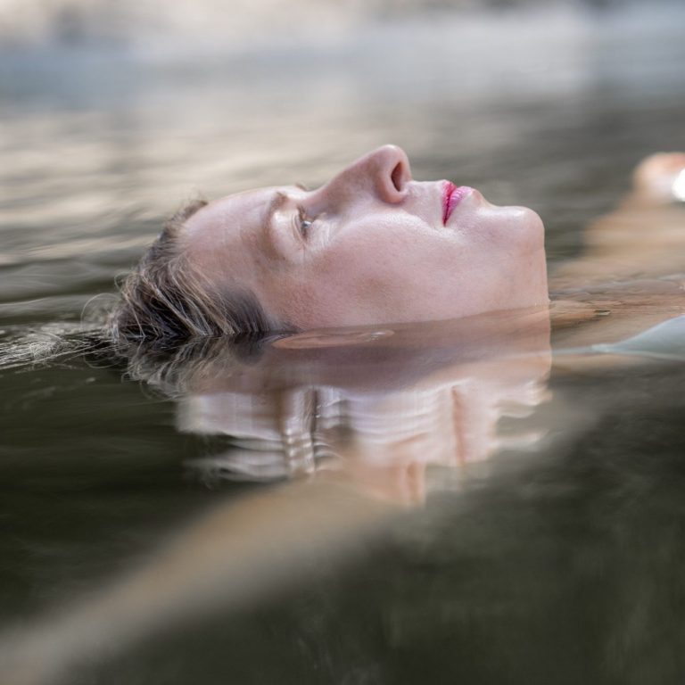Frau treibt entspannt im Wasser, Gesicht zum Himmel, Empowerment Fotografie für Frauen in Schleswig-Holstein
